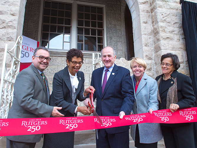 President Barchi holds the ribbon for Phoebe Haddon, chancellor of Rutgers University–Camden, to cut at the new Writers House in Camden